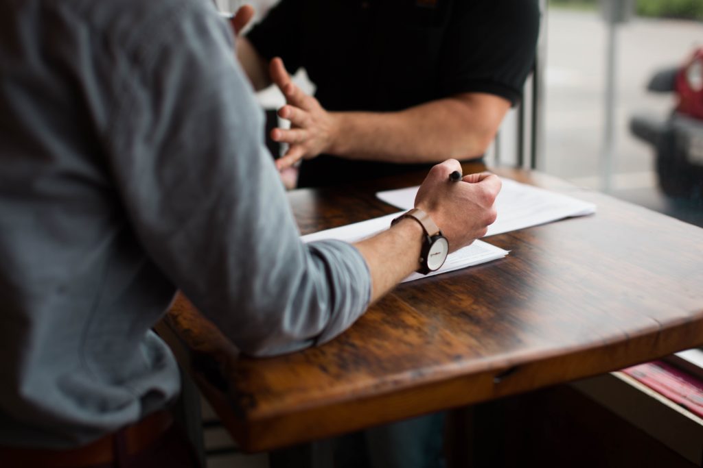 Recruiter looking over resume and talking to potential candidate.